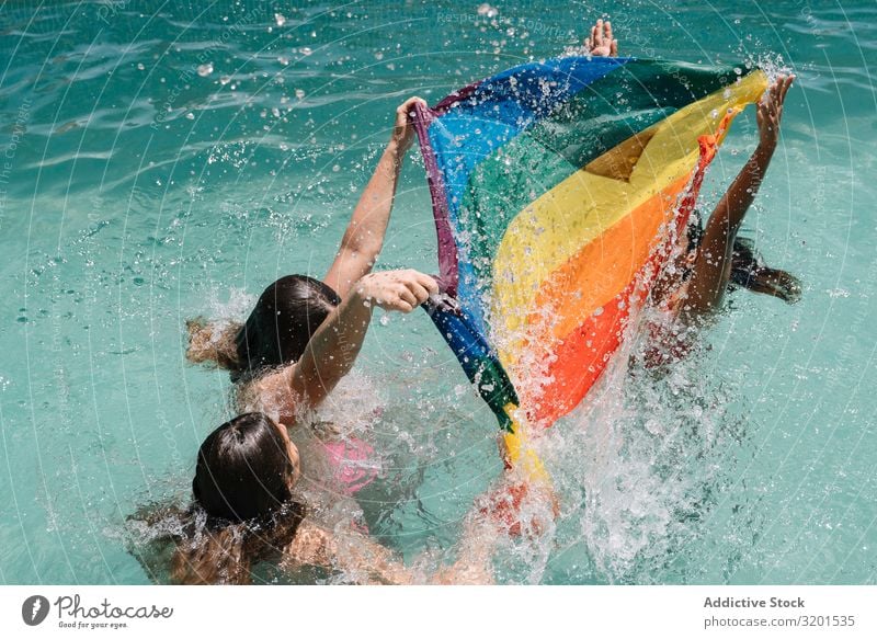 Anonymous lesbians splashing in swimming pool Swimming pool Splashing lgbt Flag falling Joy Barefoot Youth (Young adults) Woman Resort Vacation & Travel