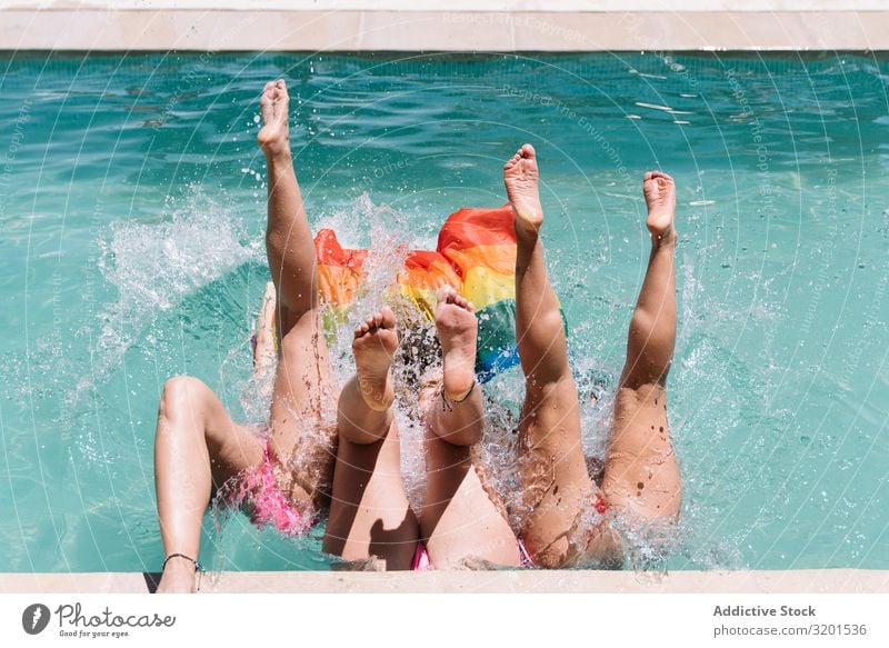 Anonymous lesbians splashing in swimming pool a Royalty Free