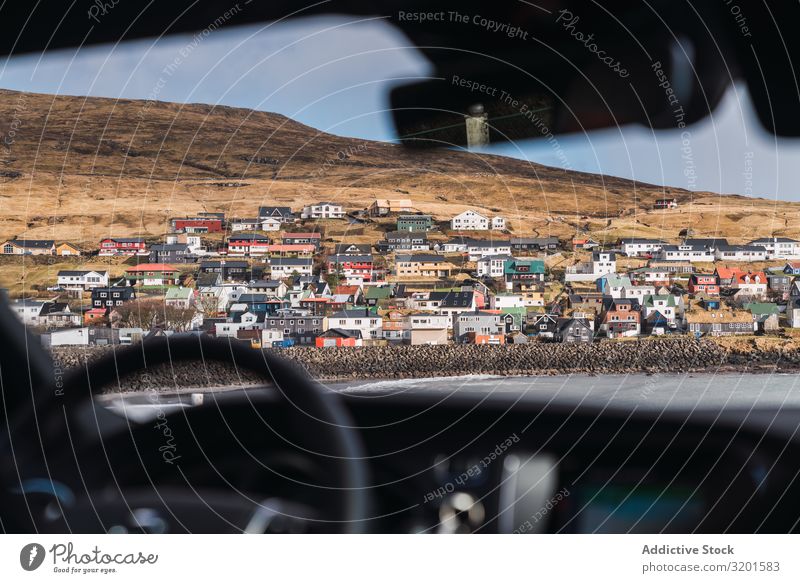 from car view of a small colorful village in Faroe Islands Town Hill Landscape House (Residential Structure) Føroyar Exterior Weather Sky Settlement Village
