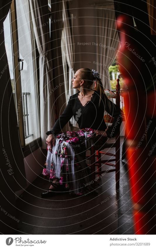 Woman dancer in suit for flamenco sitting and looking out window Dancer Dress Beautiful Expression To enjoy Flamenco Attractive Elegant Spanish Tradition