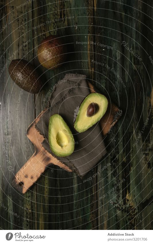 Chopped Avocados In A Bowl On Cutting Board On Wooden Background. Half  Avocado With Pulp And Seed, Whole Green Fresh Tropical Fruit On Brown  Table, Top View Stock Photo, Picture and Royalty