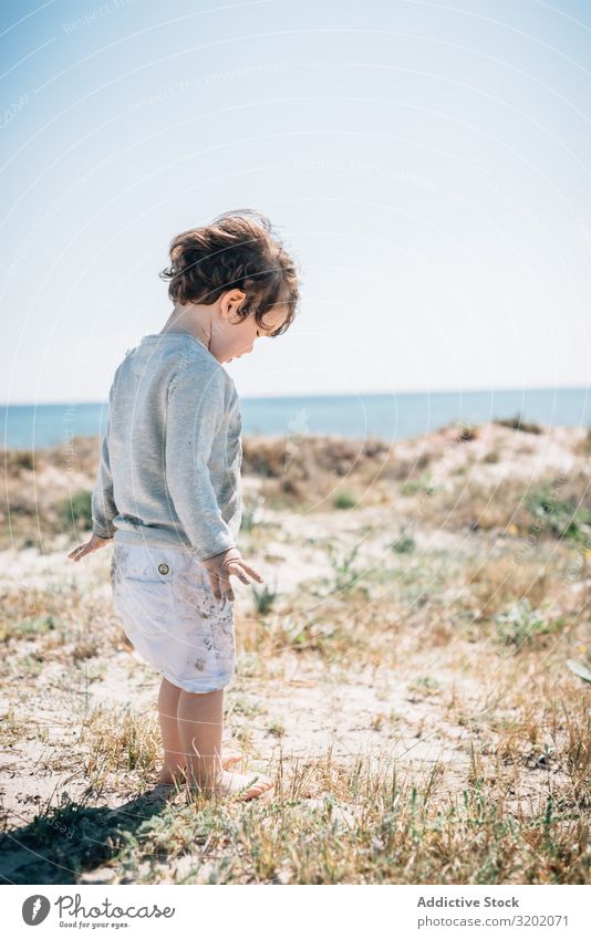 Barefoot child in short barefoot on sandy beach Child Small Sand Wave Beach babyhood Cute Joy exploring Beautiful Cheerful Infancy Discovery pretty Delightful