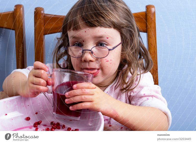 Girl tastes pomegranate juice. Face dirty of red spots Fruit Dessert Nutrition Vegetarian diet Diet Beverage Juice Lifestyle Exotic Joy Playing Child Infancy