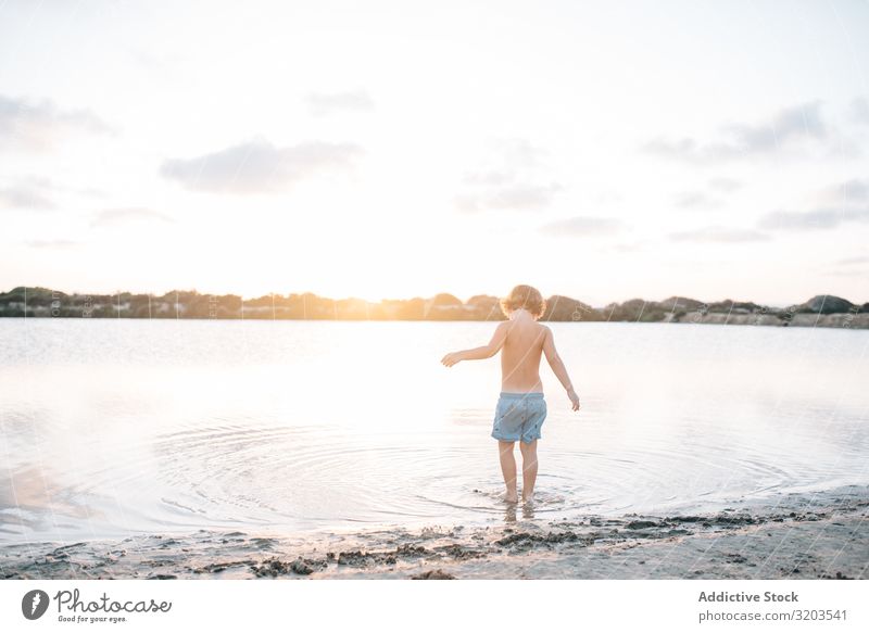 Boy walking in water of lake Boy (child) Beach Summer explore Water Walking Child Sunset Infancy Leisure and hobbies Vacation & Travel Bright Dream Loneliness
