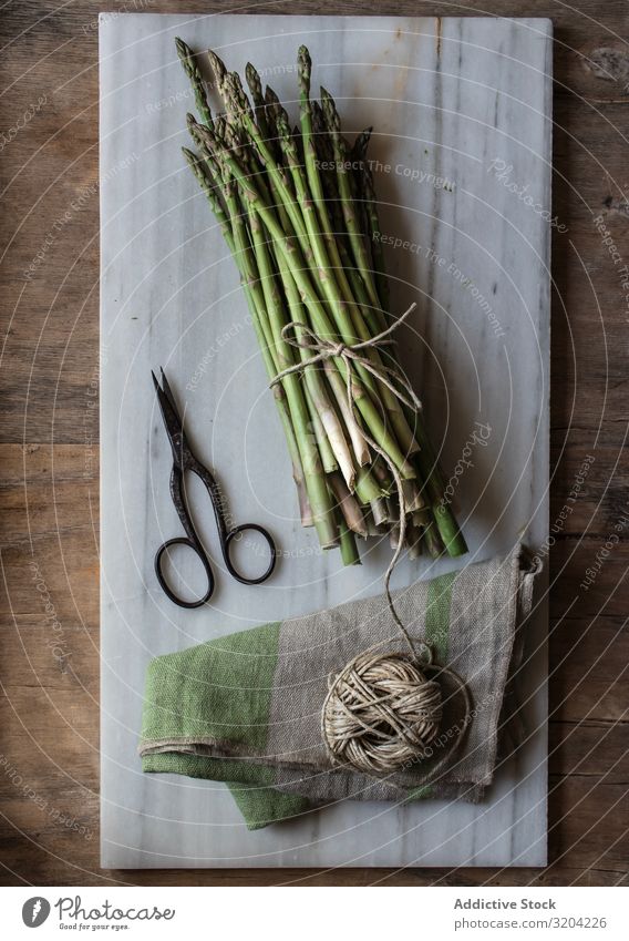 Arrangement of twine and asparagus on board Asparagus String Rustic Fresh Green Cooking Vegetable bunch Raw Healthy Nutrition Vegetarian diet Ingredients Diet
