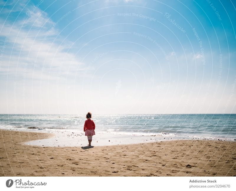 Girl walking on beach in sunny day Beach Walking Sunbeam Day Toddler Sand seaside Water Calm Coast Infancy Vacation & Travel Action Child enjoying Positive