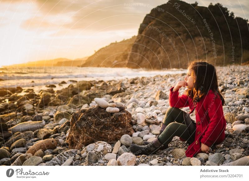 Dreamy girl resting on beach at sunset Girl Child Resting Beach Sunset Pensive admiring Calm seaside Woman Beautiful Relaxation Leisure and hobbies To enjoy