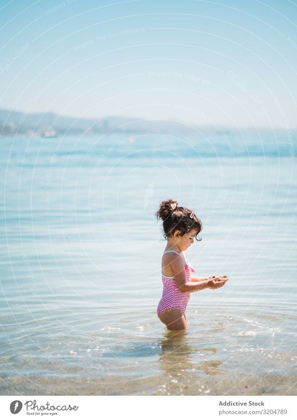Cute girl playing in water of seaside Girl Water Playing Toddler Delightful Ocean swimming suit Warmth Beach Sunbeam Infancy Swimming & Bathing enjoying Serene