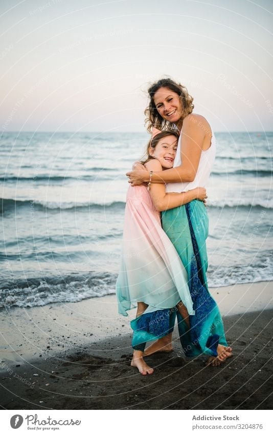 Beautiful mother and daughter embracing on beach Woman Daughter Beach Embrace Love Happy Beauty Photography Mother Family & Relations Together Child Style Ocean