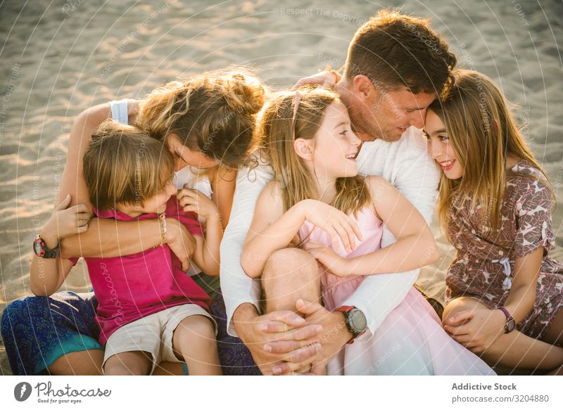 Beautiful happy family with playful children on beach Family & Relations Love Beach Happy Parents Child Group sibling Summer Vacation & Travel Sit Embrace Sand