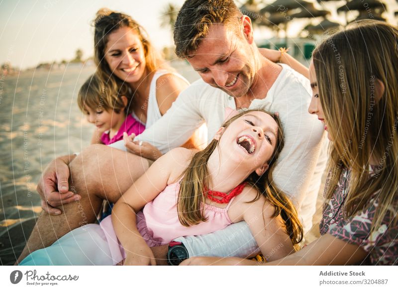 Beautiful happy family with playful children on beach Family & Relations Love Beach Happy Parents Child Group sibling Summer Vacation & Travel Sit Embrace Sand