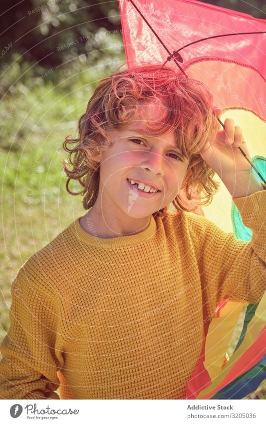 Cheerful boy holding colorful kite Boy (child) Kite Joy Teeth missing Infancy Playing Child Small Man Human being Happy Curly Delightful Beautiful Playful Cute