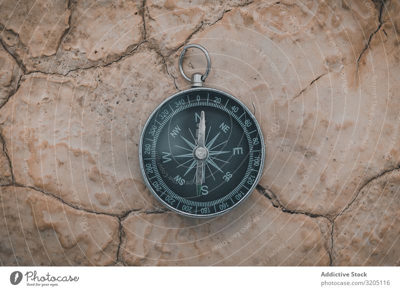 Big compass on dry cracked desert area Compass (drafting) Direction Desert Equipment Orientation Sand Adventure Vacation & Travel exploration Geography Magnetic