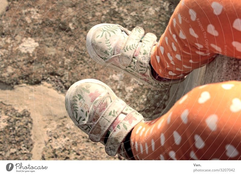 walking in my shoes Child Girl Legs Feet 1 Human being Wall (barrier) Wall (building) Pants Footwear Sit Orange Heart Floral Pattern Stone Ground Colour photo