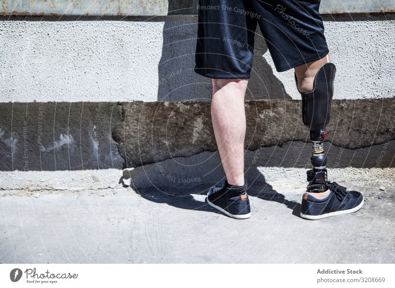 Unrecognizable young man amputated with his leg prosthesis expression disable male handicapped sit young adult amputation organ alone isolated disability care