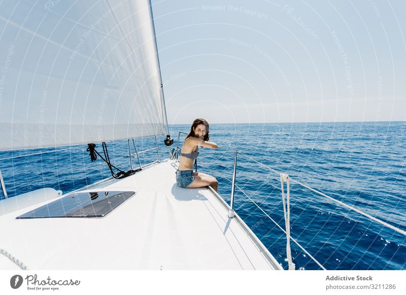 Woman in swimsuit sitting on boat woman sea slim travel holiday beak summer sunny young bikini yacht vacation female lifestyle tourism cruise trip journey