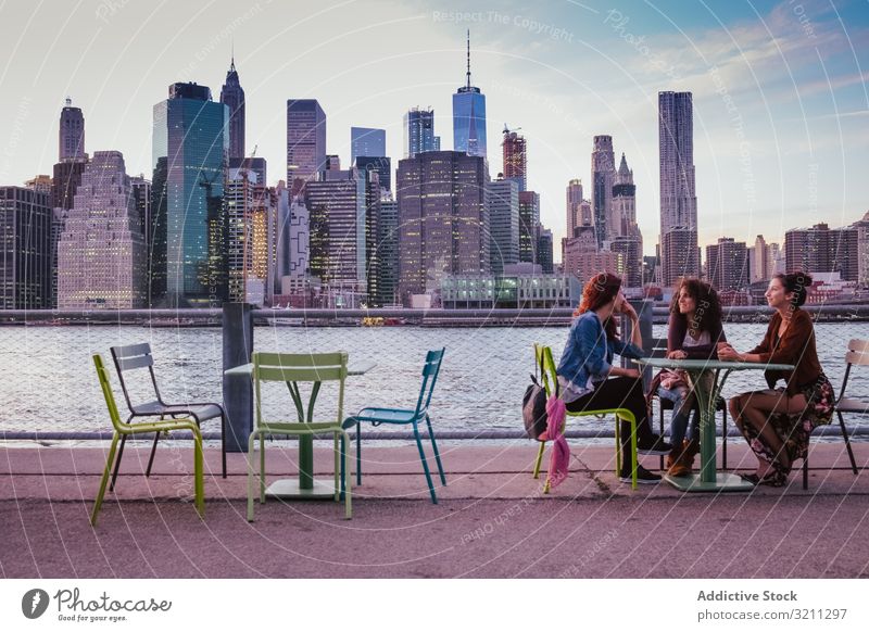 friends sitting on terrace with new york background at evening city view bridge river skyscraper architecture building cityscape travel modern urban landmark
