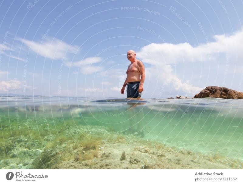 Back view of men in hats observing beautiful mountain landscape floating on  boat on turquoise water in Halkidiki, Greece Stock Photo