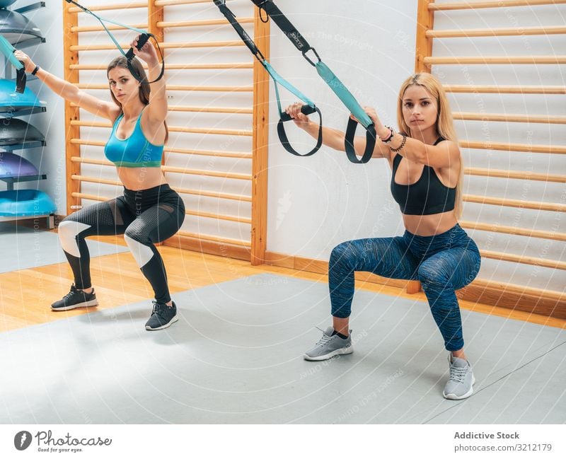 Two young women working out in gym, using gym equipment, Stock