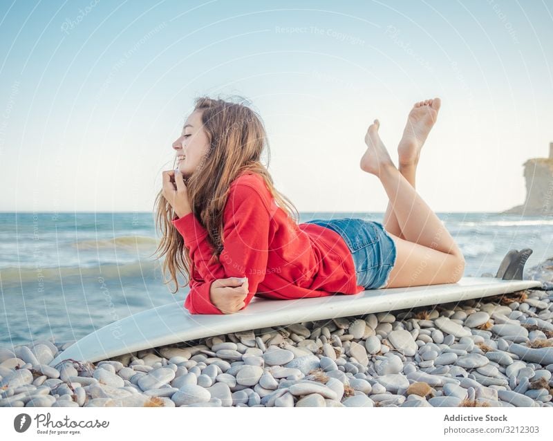 Cheerful woman lying on surfboard with crossed legs relaxation smile ocean holiday pretty sport beach cheerful beautiful female happy attractive vacation adult
