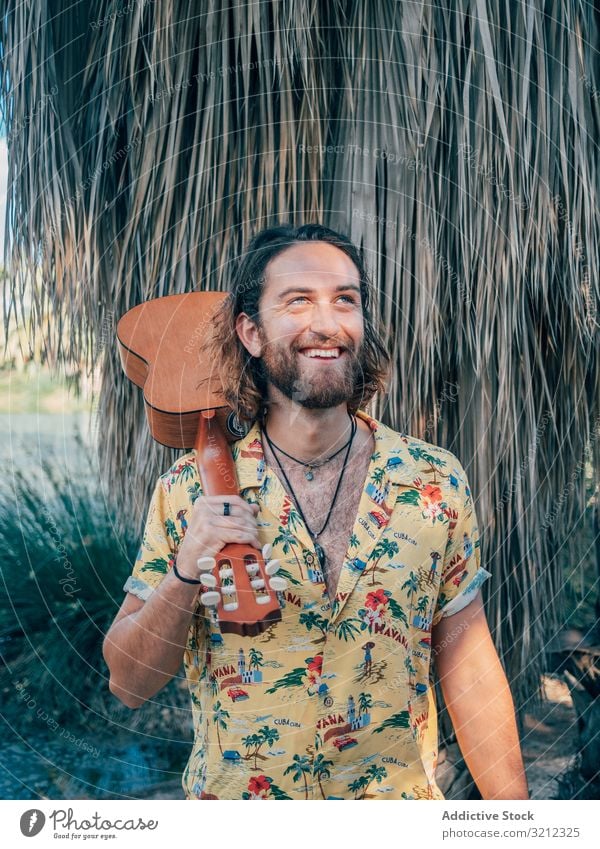 Hipster man in jungle with ukulele hipster musician travel adventure trip summer lifestyle pensive male vacation freedom young tourist colorful casual tropical