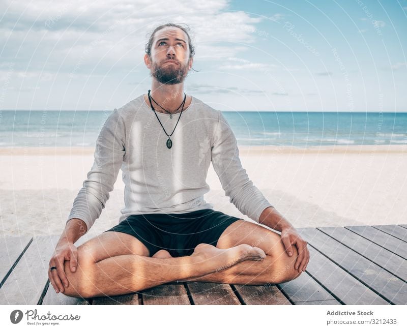 Man meditating on beach man meditate rest calm lotus position resort brutal harmony relax summer beard practice yoga hobby asana sport vacation active sitting