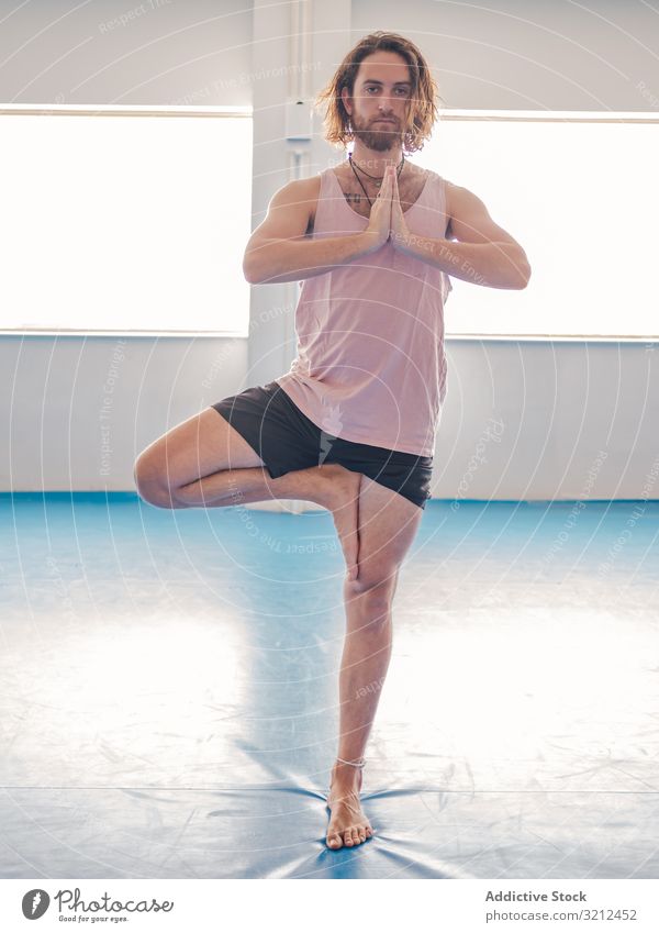 Male doing yoga in spacious room man gym relax vitality zen harmony fitness exercise asana sport young calm peace male bearded happy handsome slender tranquil