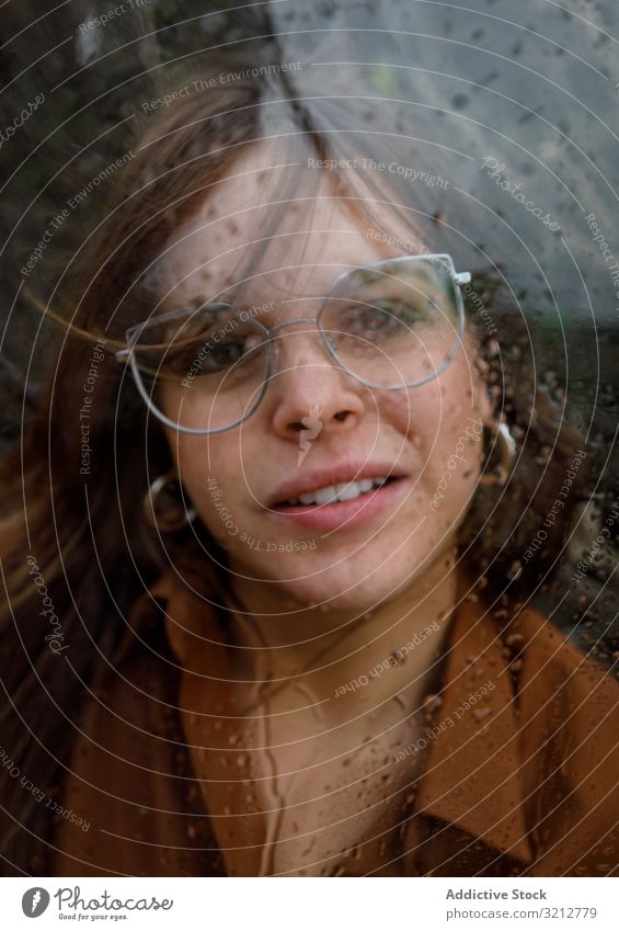 Woman looking out of window in rain woman through window glasses alone relax day attractive wet female adult young lifestyle lonely calm gorgeous brunette