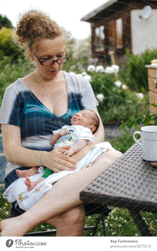 caucasian mother with her newborn baby sitting outside in her garden affection beautiful blonde bonding care chair child childhood cute happiness happy holding