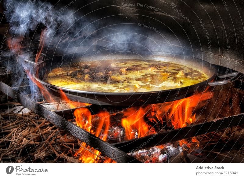 https://www.photocase.com/photos/3215941-process-of-cooking-paella-on-fire-rice-process-photocase-stock-photo-large.jpeg