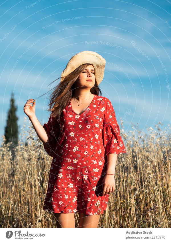 Happy dreamy woman standing among high grass field happy attractive smiling straw hat red dress blue sky nature summer young lifestyle positive happiness
