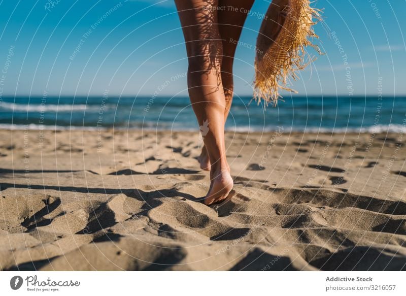 Woman legs on sandy beach woman crop anonymous unrecognizable horizontal back view swimwear hat water walking ocean summer enjoying leisure body happy slim