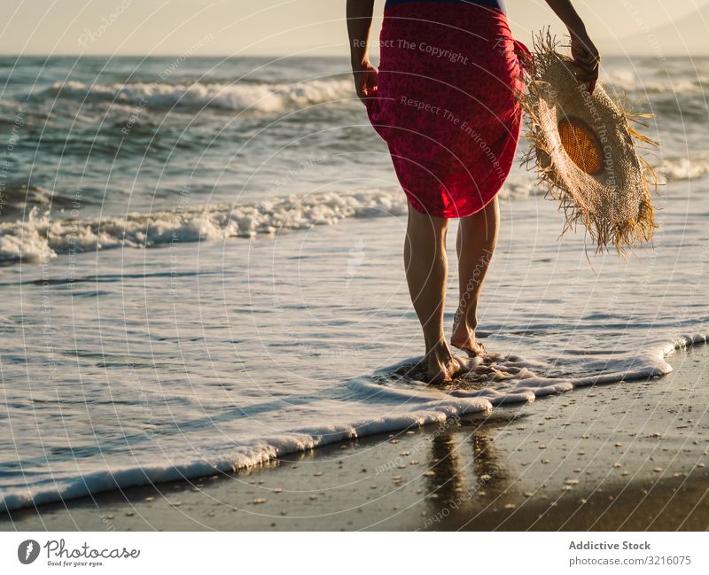 Woman with pink pareo on sandy beach woman crop anonymous unrecognizable horizontal back view swimwear hat water walking ocean summer enjoying leisure body