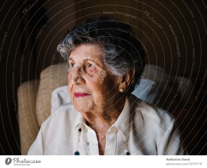 Portrait of aged female in white shirt at home woman grandmother experience wisdom attention grandparent generation senior elderly wrinkle granny gray haired