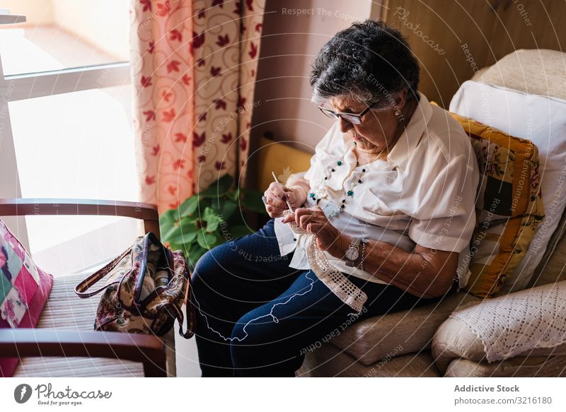 Elderly female taking knitting tools at home aged woman yarn basket experience wisdom grandmother hobby handmade attention grandparent generation senior elderly