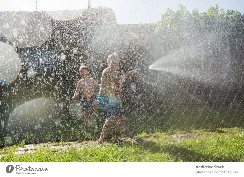 Little kids in swimwear having fun with splashing water children summer playing happy lifestyle leisure recreation holiday childhood joy enjoyment amusement