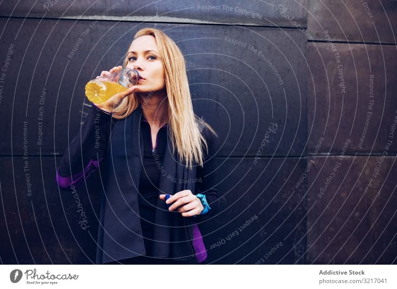 Woman drinking isotonic drink while resting active athletic beautiful blonde body cardio caucasian exercise fitness gym healthy jog lifestyle outdoors runner