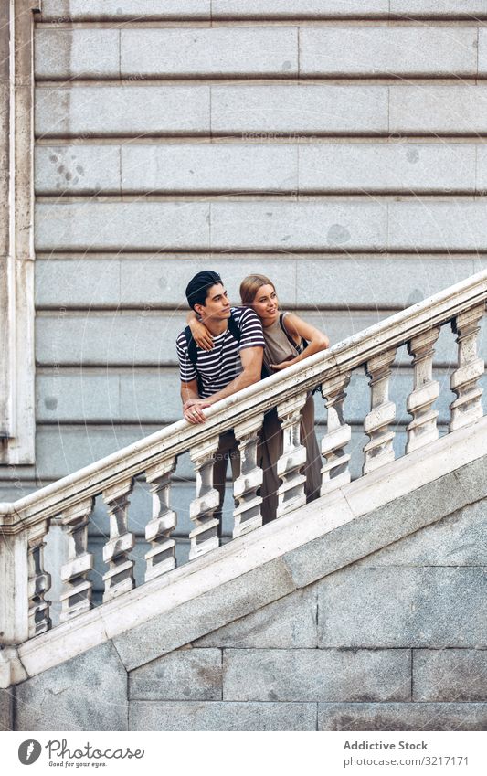 Young couple standing on ancient stairs against wall admiring young old building historical attractive love woman romance relationship architecture railing