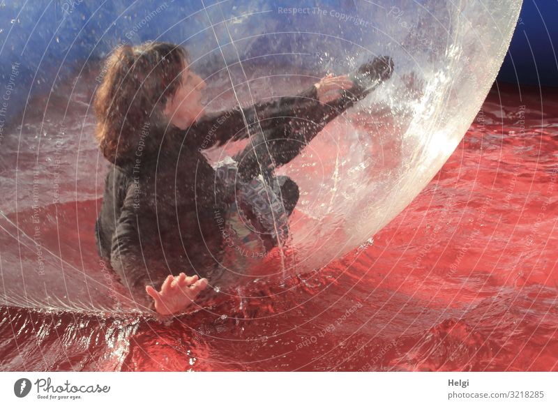 Woman with brunette long hair moves in a big plastic ball in a water basin Human being Feminine Adults 1 45 - 60 years T-shirt Skirt Hair and hairstyles
