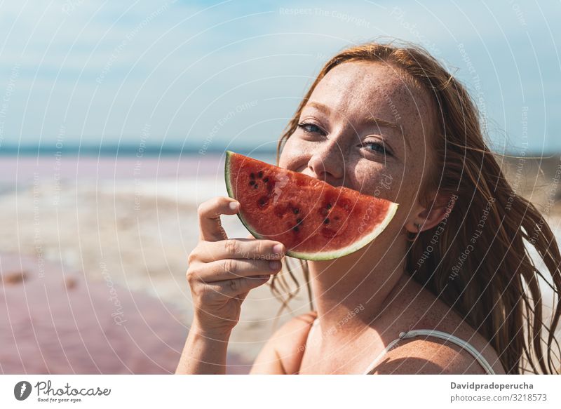 cute teenager woman covering face with watermelon smiling portrait red head looking at camera ginger pretty happiness Spain freckles girl freckled beach
