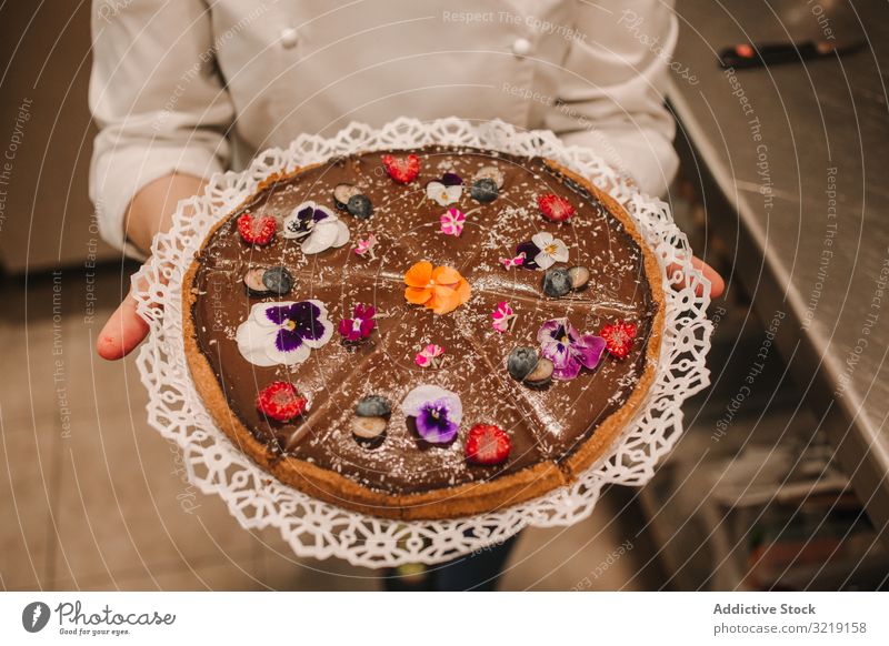 Brown pie decorated with flowers in woman hands cake homemade sweet bakery gourmet organic nutrition tasty appetizing refreshing raw delicious holiday