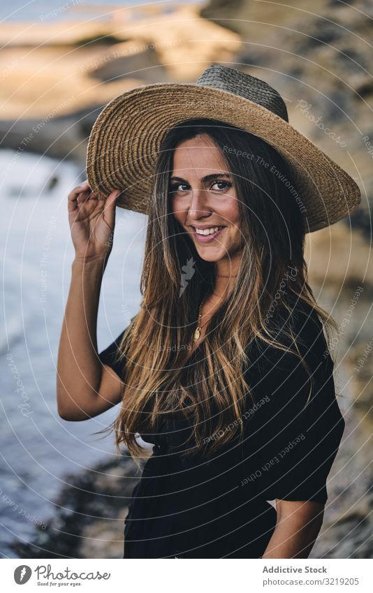 Cheerful woman holding hat in air model cheerful beach nature smile stylish young attractive beautiful pretty summer female natural elegant posing travel