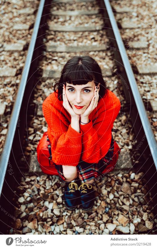 Woman sitting on sleepers in middle of railway woman railroad suitcase red travel stylish green female luggage nature beautiful bag waiting freedom alone trip