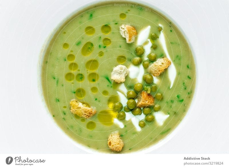 Green vegetable cream soup with peas and crackers green summer aromatic traditional tasty veggie meal food delicious vegetarian gourmet fresh ingredient orange