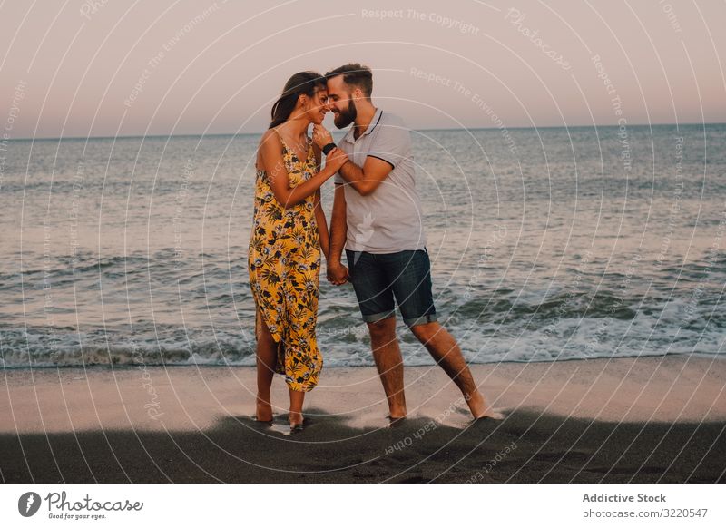 Loving couple embracing happily on sandy beach hugging bonding lovely amorous romantic feelings sea happy anniversary together relationship vacation gently