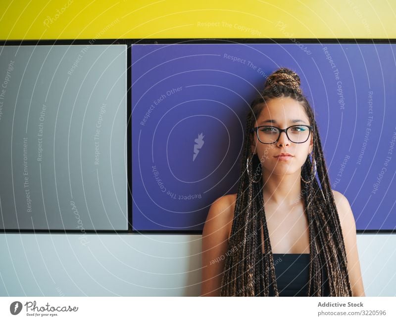 Charming teenage girl with braids in sunglasses nearby colorful wall earrings charming braided stylish teenager fun attractive fashion beautiful smart casual