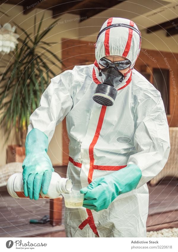 Man in suit for fumigation pouring chemical into tank man fumigator respiratory pesticide poison insect disinfection yard mask plant protection mosquito