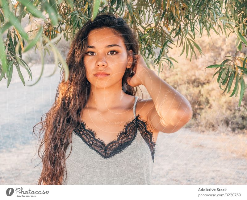 Playful trendy young ethnic woman in deserted countryside modern casual cactus sandy dry bush sunlight adult brunette attractive stylish hipster summer