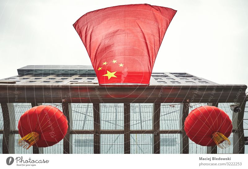 Looking up at Chinese flag and red lanterns on a building. Sky Wind Town Building Roof Flag Flying Red Symmetry Future Symbols and metaphors China Lantern