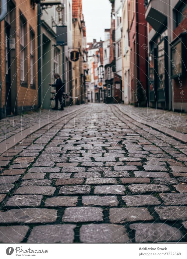 Narrow stone pavement street with houses in city cobblestone architecture town narrow building perspective exterior urban traditional footpath sidewalk